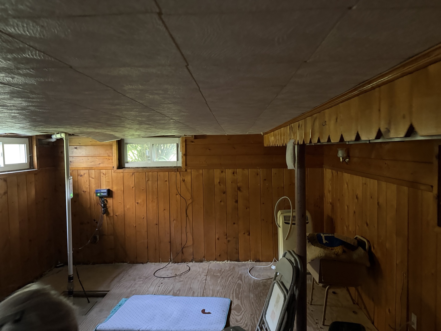Basement in Ashland MA before EcoHaul removed wood paneling, ceiling tiles, and flooring